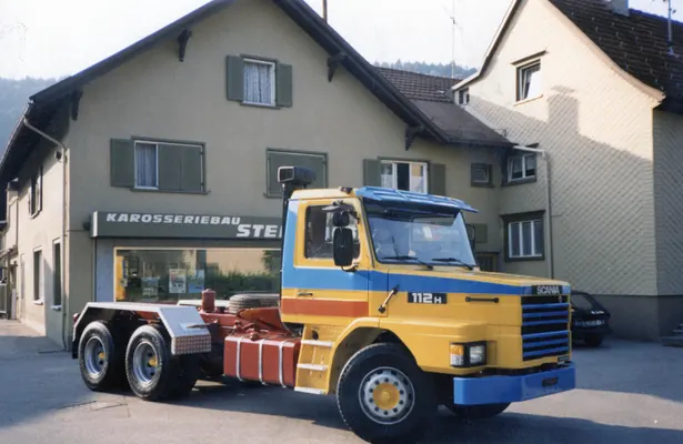 Scania-Fahrgestell mit Wechselrahmen vor einem Haus