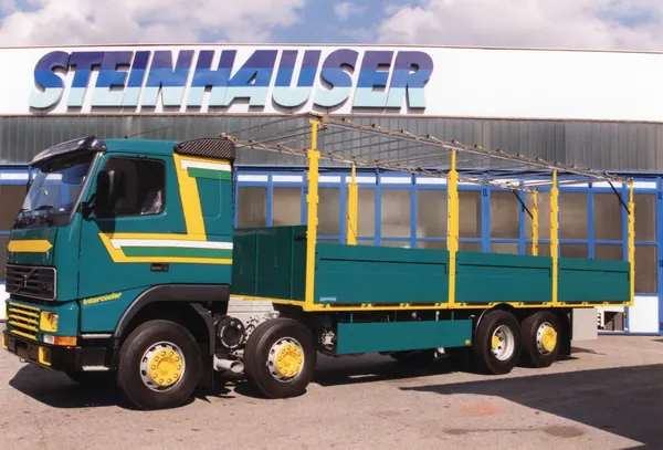 Volvo-Vierachser mit Pritsche und Planengestell vor dem Steinhauser-Gebäude