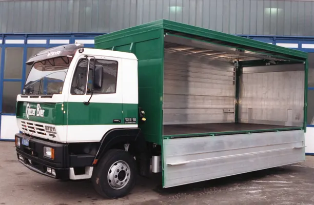 Lkw mit grünem Getränkeaufbau und geöffneter Seitenwand