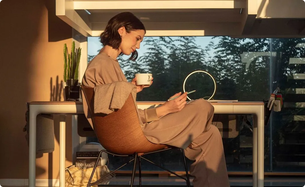 Woman reading with a cup of coffee by a sunny window