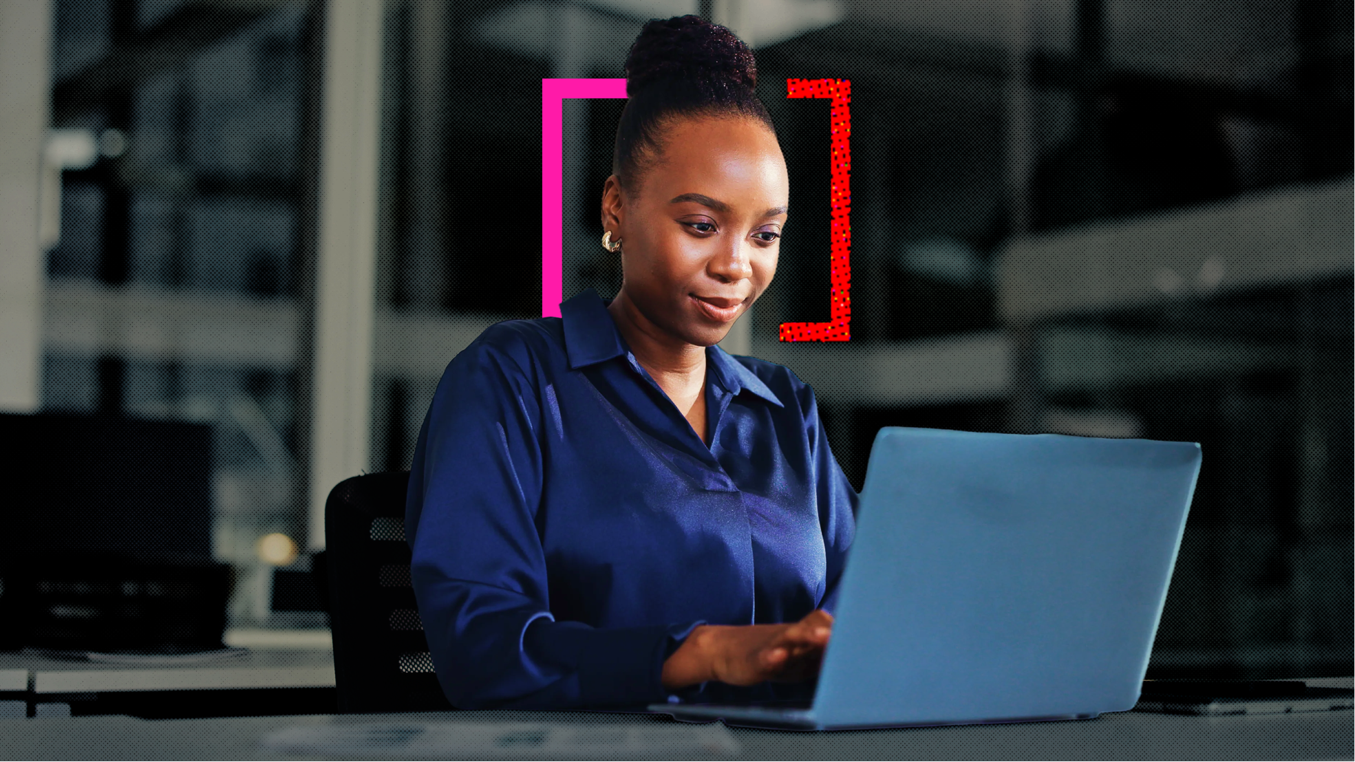 A woman sitting at a desk in her office chair, surrounded by a tablet and papers as she checks her laptop at work.