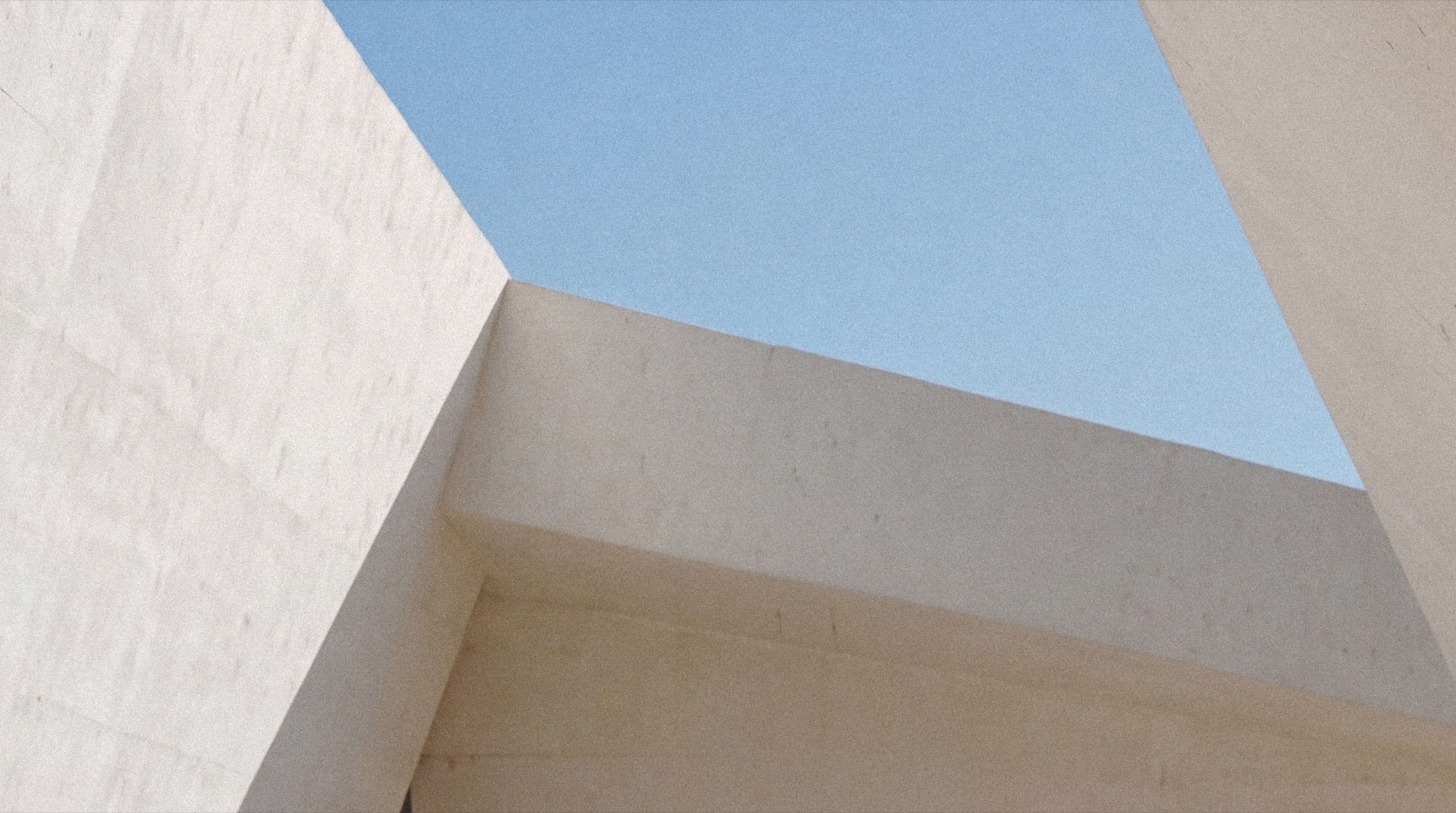 Sunlit concrete planes against a clear Dubai sky
