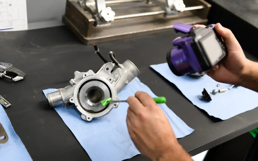 Technician testing a turbocharger actuator on a workbench