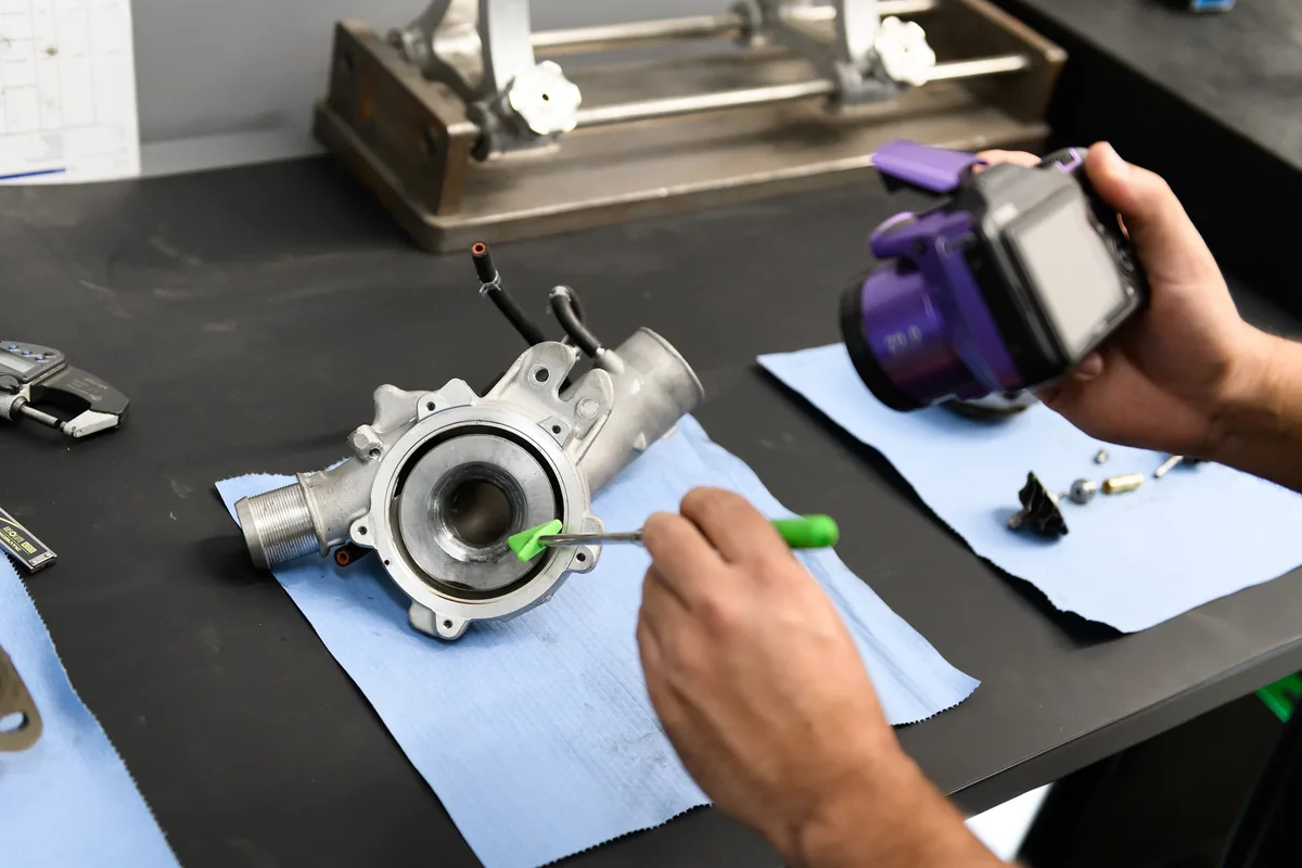 Technician hand-matching a Cloyes timing component on the bench