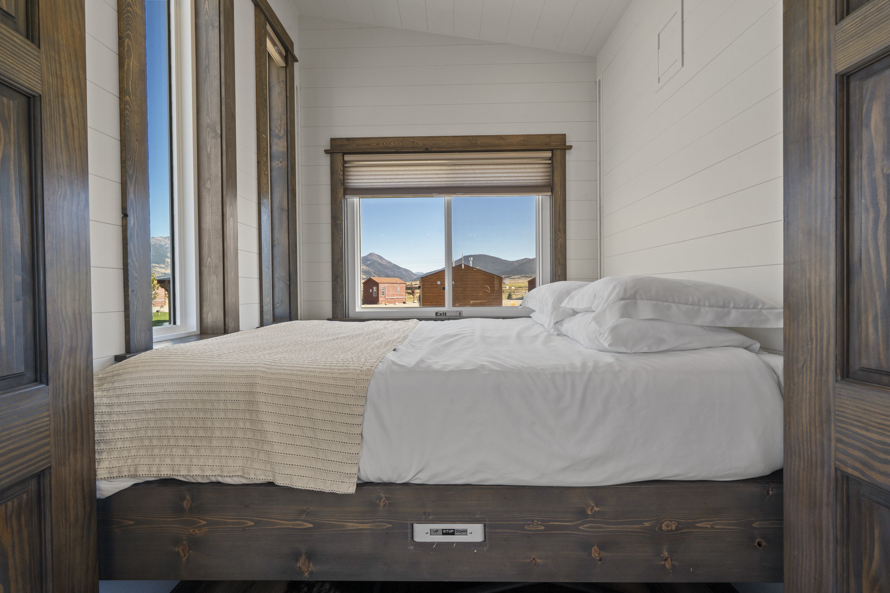 Royal Wulff main-floor queen bed with windows looking out to the cabins and mountains