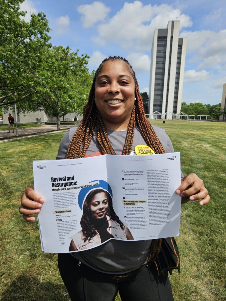 A woman smiles at the camera while holding open a magazine that features her image and story
