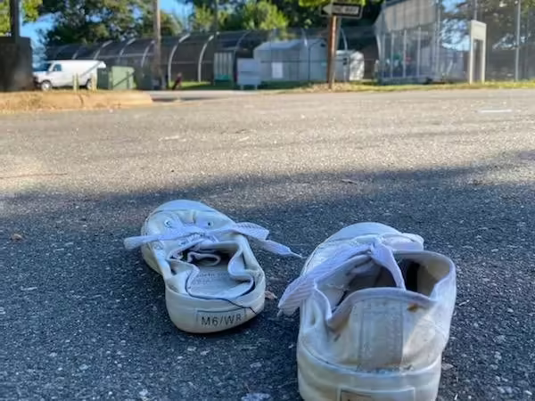 A worn pair of slip-on shoes on pavement
