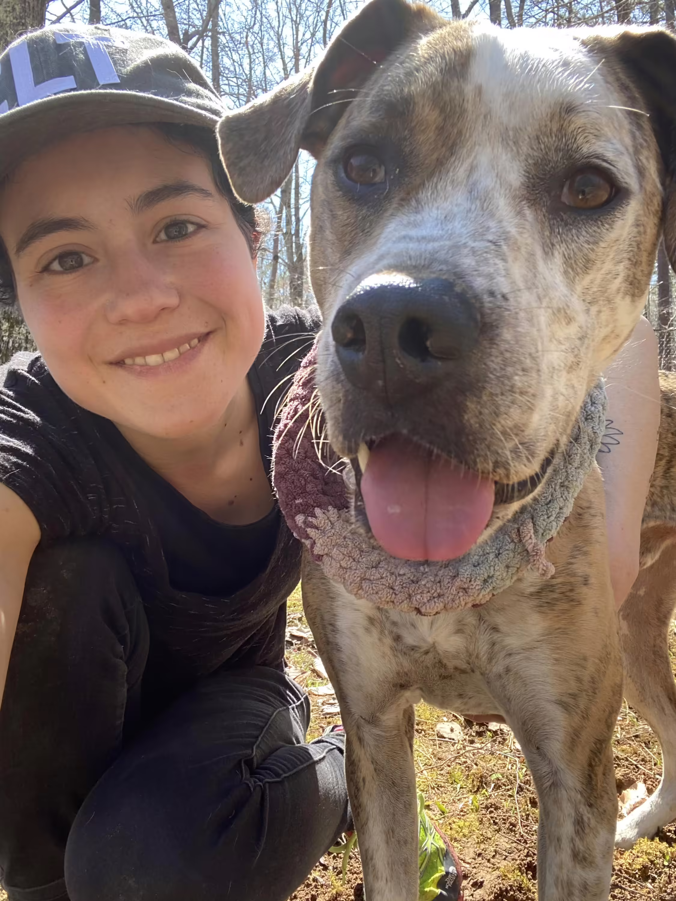 A staff member smiling next to a dog