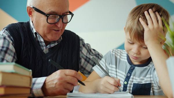 Un grand-père aide son petit-fils à faire ses devoirs