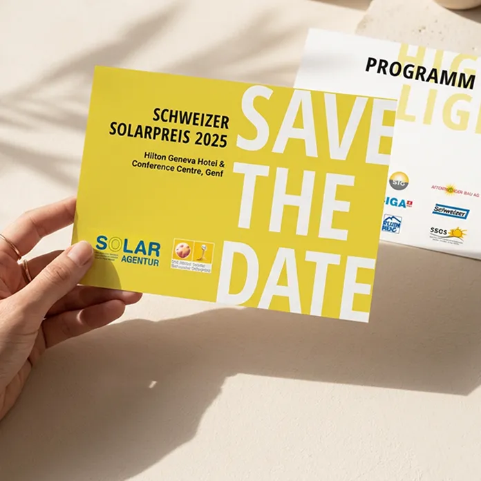 Hand hält eine Save-the-Date-Karte zum Schweizer Solarpreis 2025