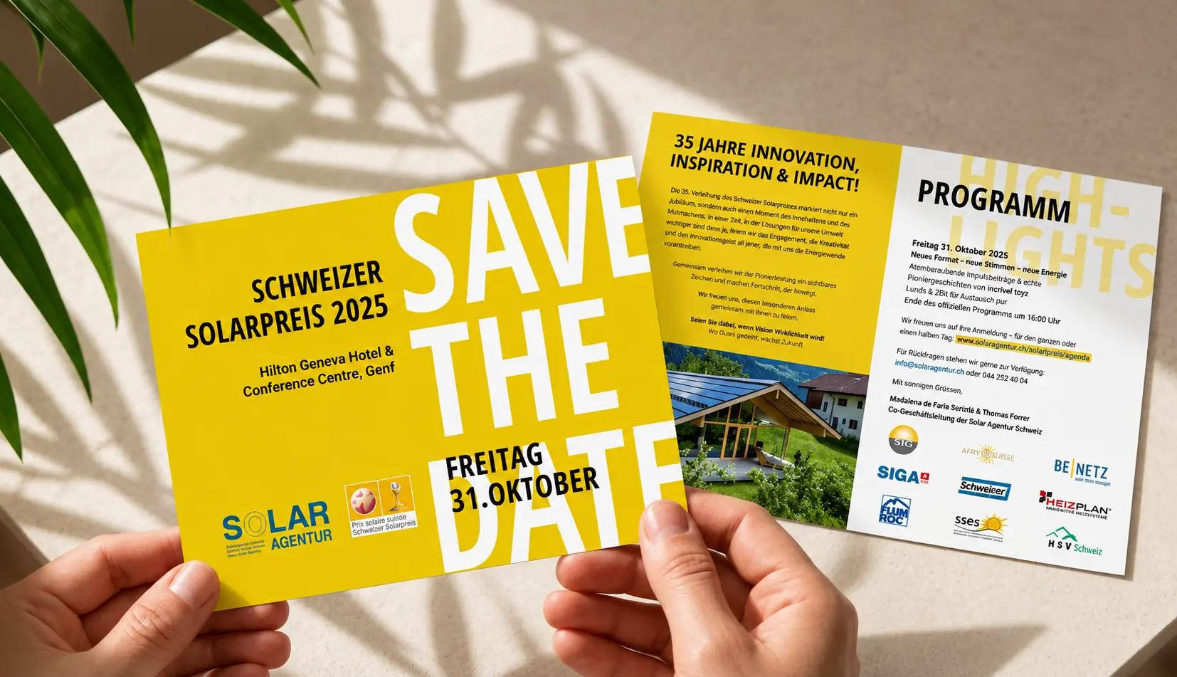 Zwei Hände halten Save-the-Date-Karte und Programm zum Schweizer Solarpreis 2025