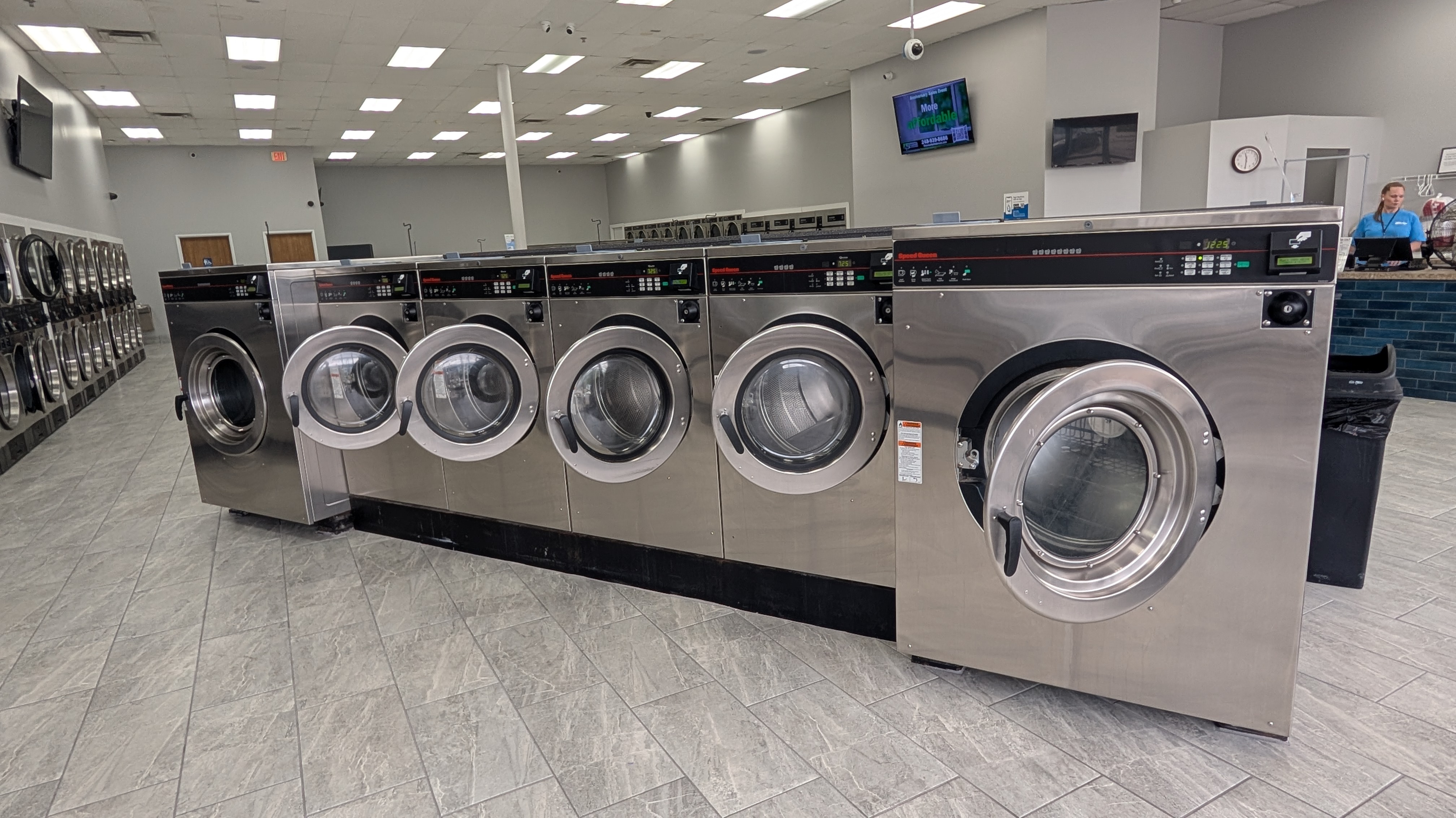 Wide view of the Speed Queen washer row and service counter inside Lafayette Laundromat