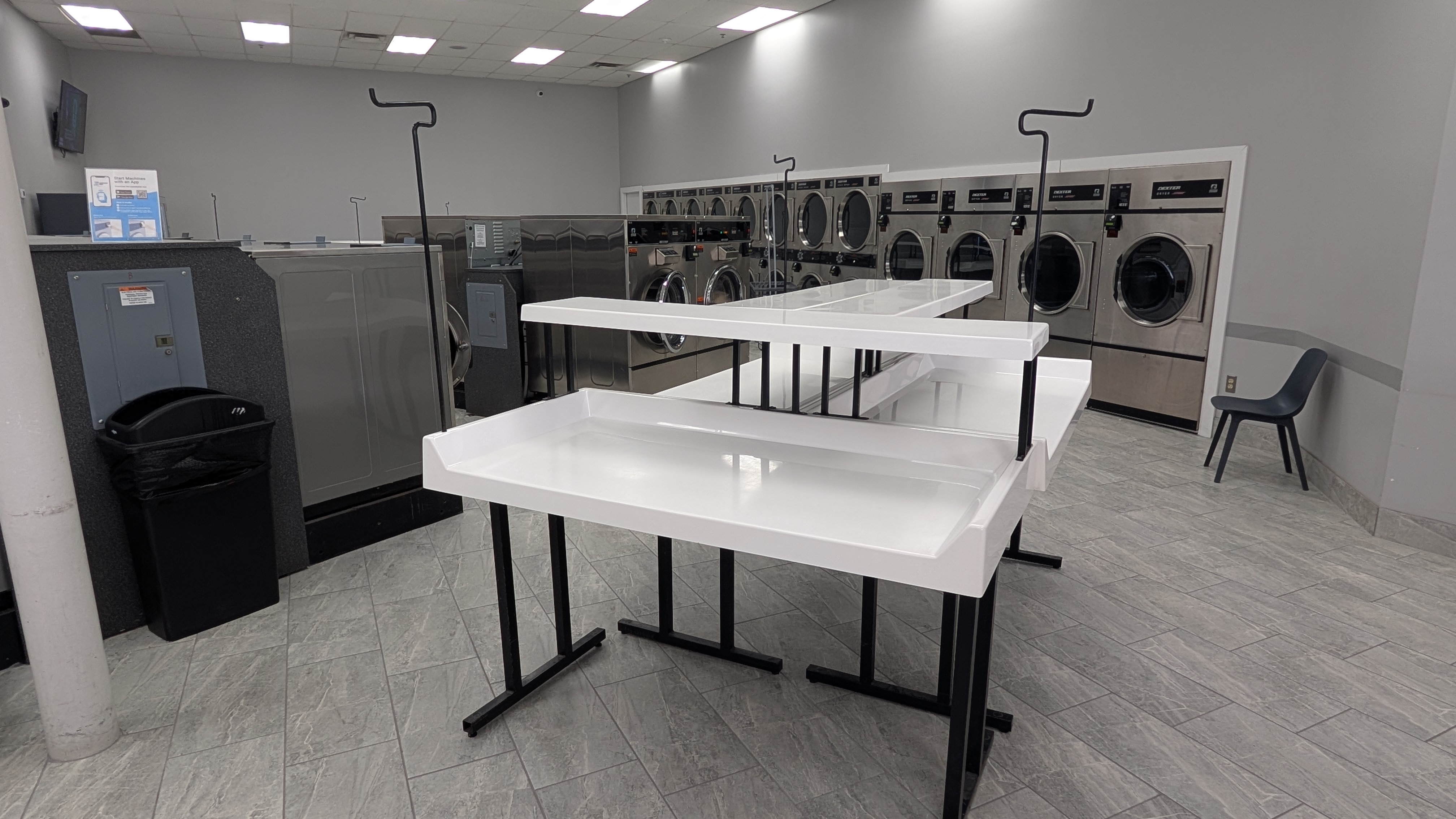 White folding tables and Dexter dryers in the folding area