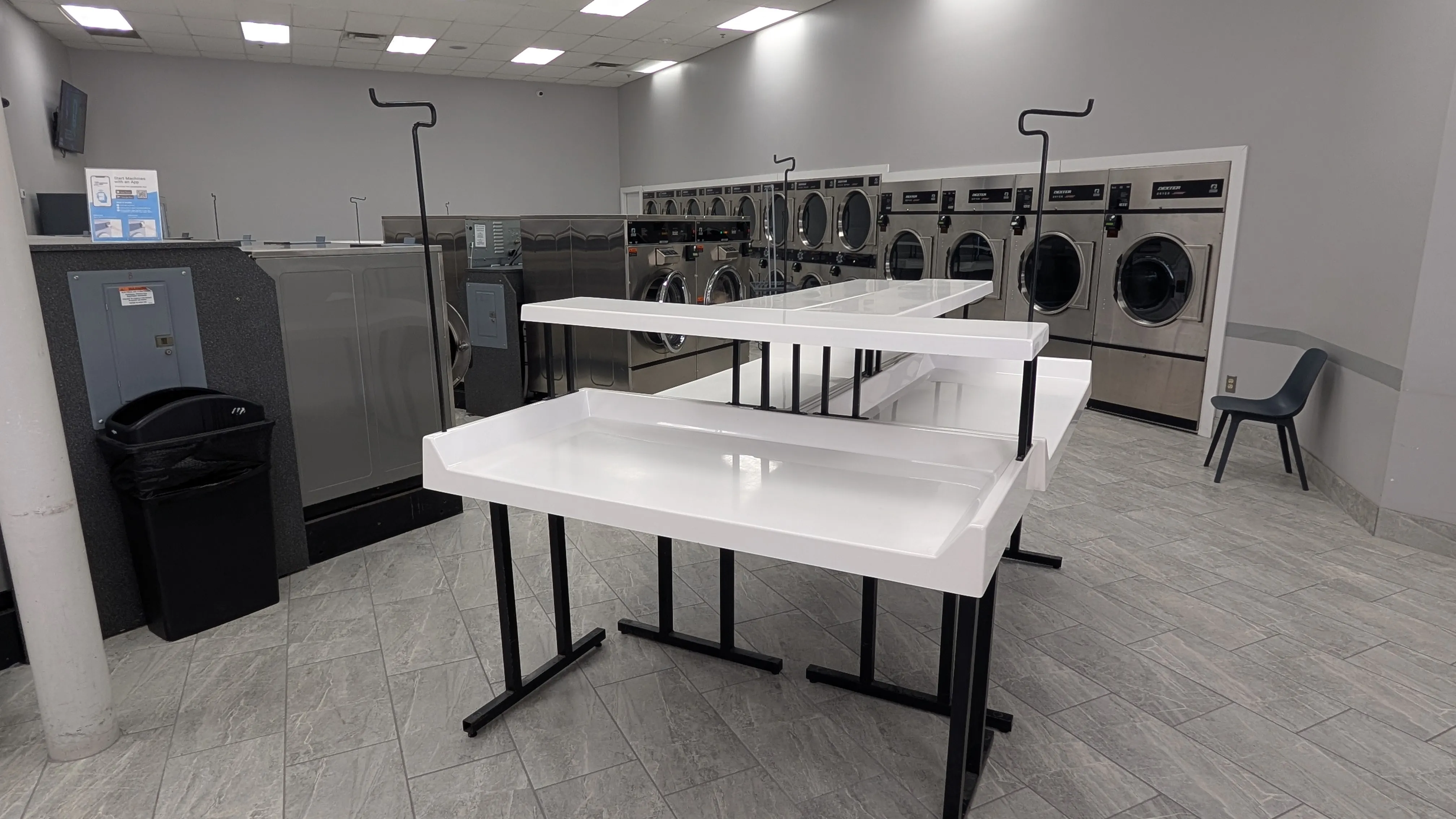 White folding tables and Dexter dryers in the folding area
