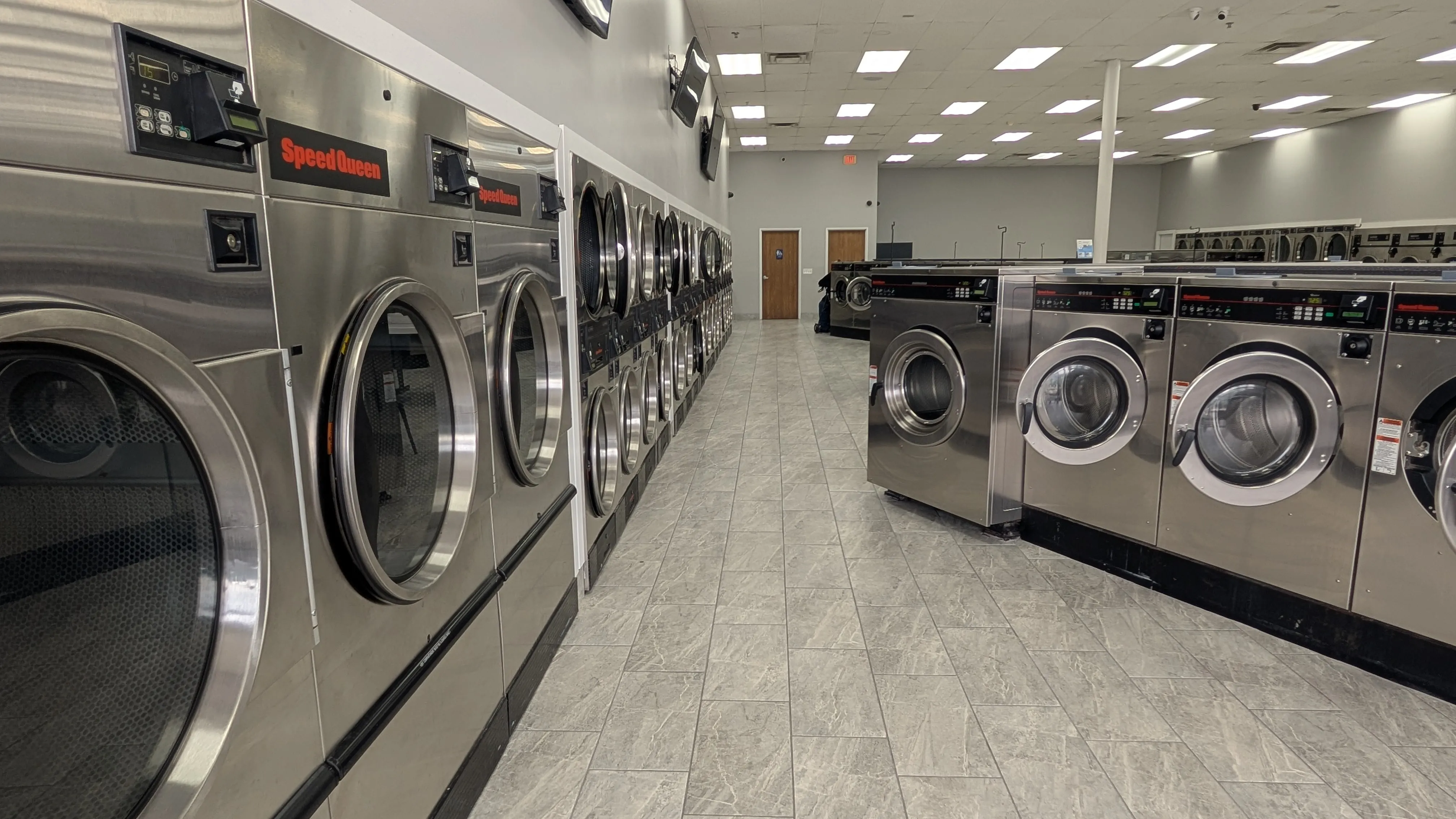 Wide view down the aisle between two rows of washers at Lafayette Laundromat