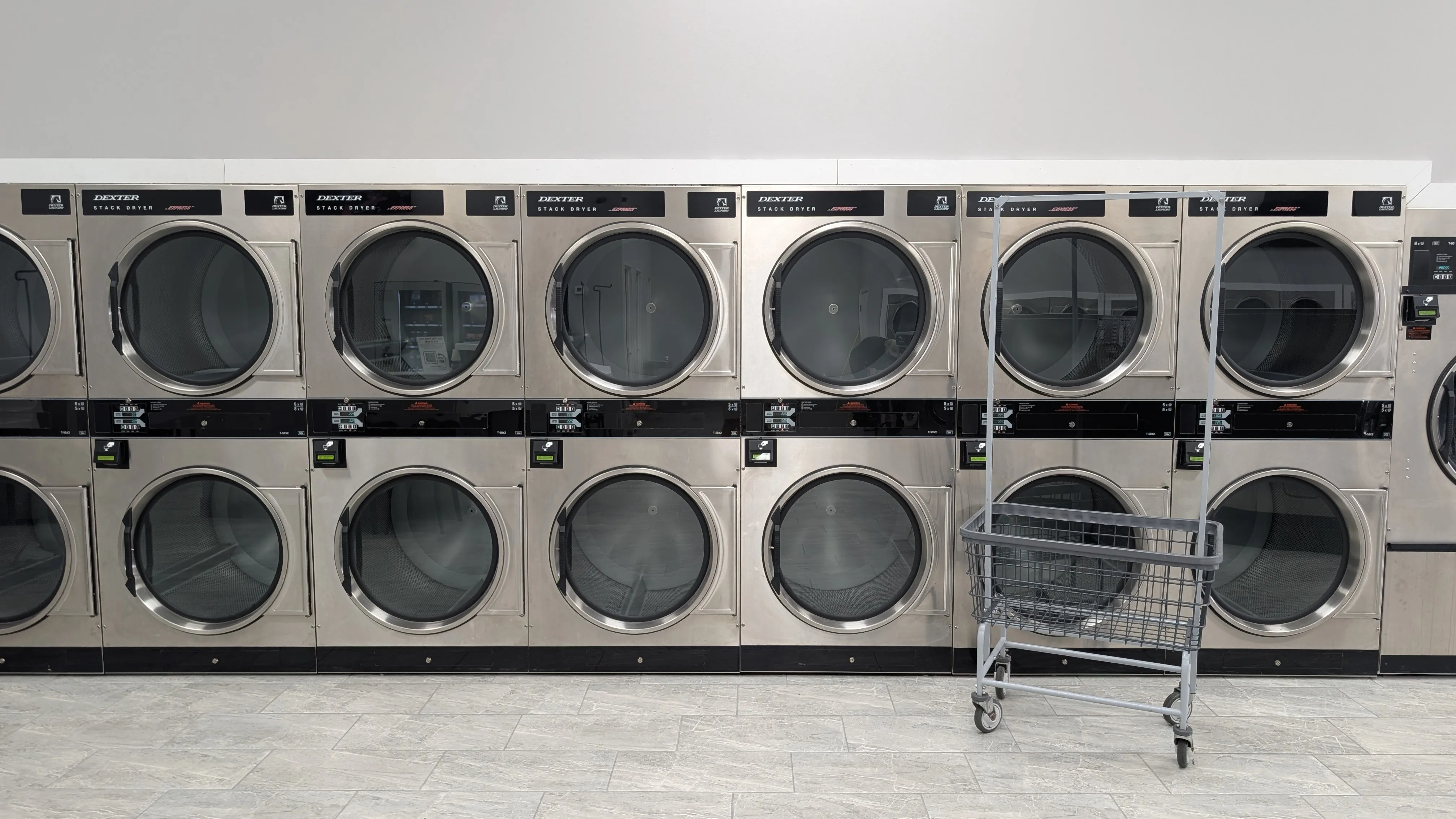 Row of Dexter stack dryers with a laundry cart at Lafayette Laundromat
