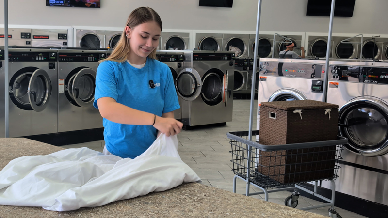 Attendant holding freshly folded sheets