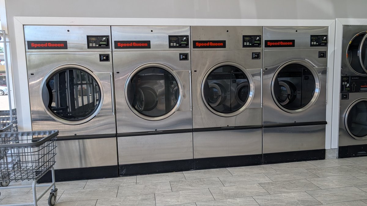 Four Speed Queen washers with a laundry cart alongside