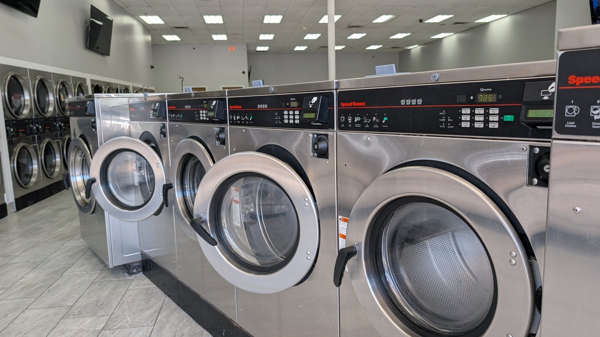 Speed Queen washers under the laundromat ceiling lighting