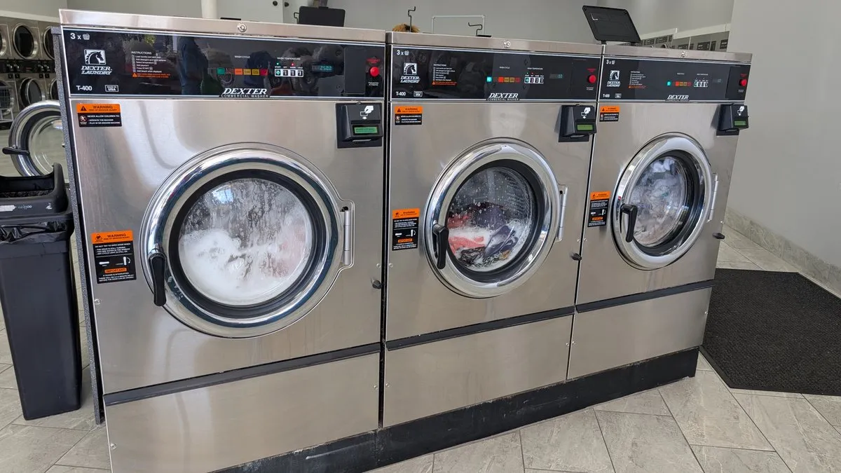 Three Dexter commercial washers running a wash cycle