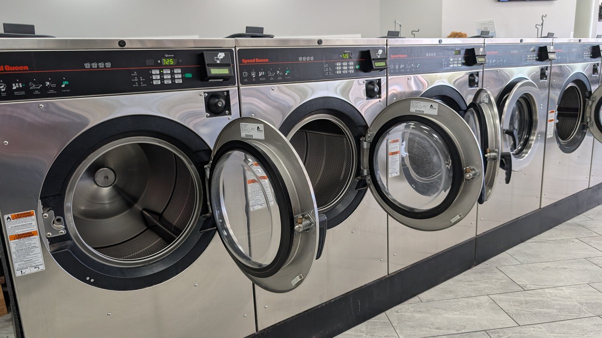 Row of Speed Queen washers with doors open, ready to load