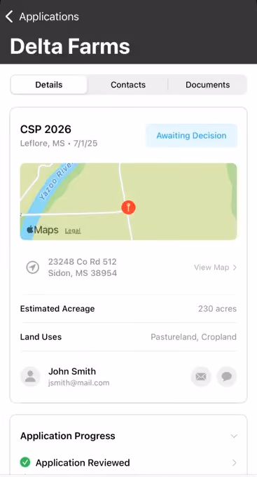 Mobile app screen showing details for application 'Delta Farms' with tab options Details, Contacts, Documents. Under Details, application CSP 2026 located in Leflore, MS with status Awaiting Decision. A map snippet with a pin near Yazoo River is displayed. Below, address 23248 Co Rd 512, Sidon, MS 38954, estimated acreage 230 acres, land uses include pastureland and cropland. Contact information for John Smith with email jsmith@mail.com is listed. Application Progress section indicates Application Reviewed with a checkmark.