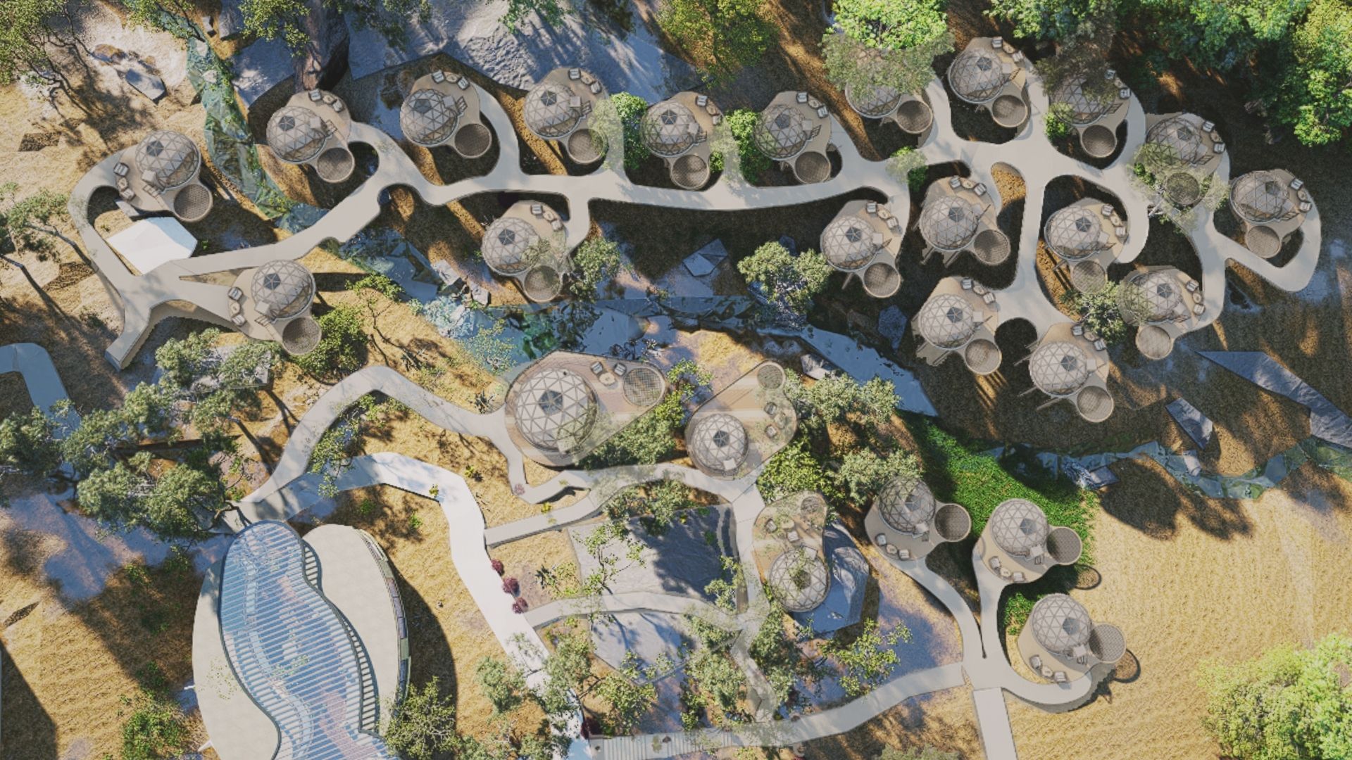 Aerial view of a planned glamping community with multiple round dome-shaped buildings connected by winding pathways, surrounded by trees, grassy areas, and a central stream.
