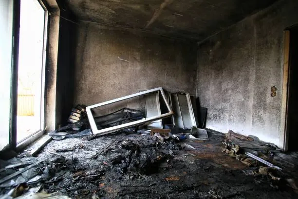 Charred debris and a burnt window frame after a fire