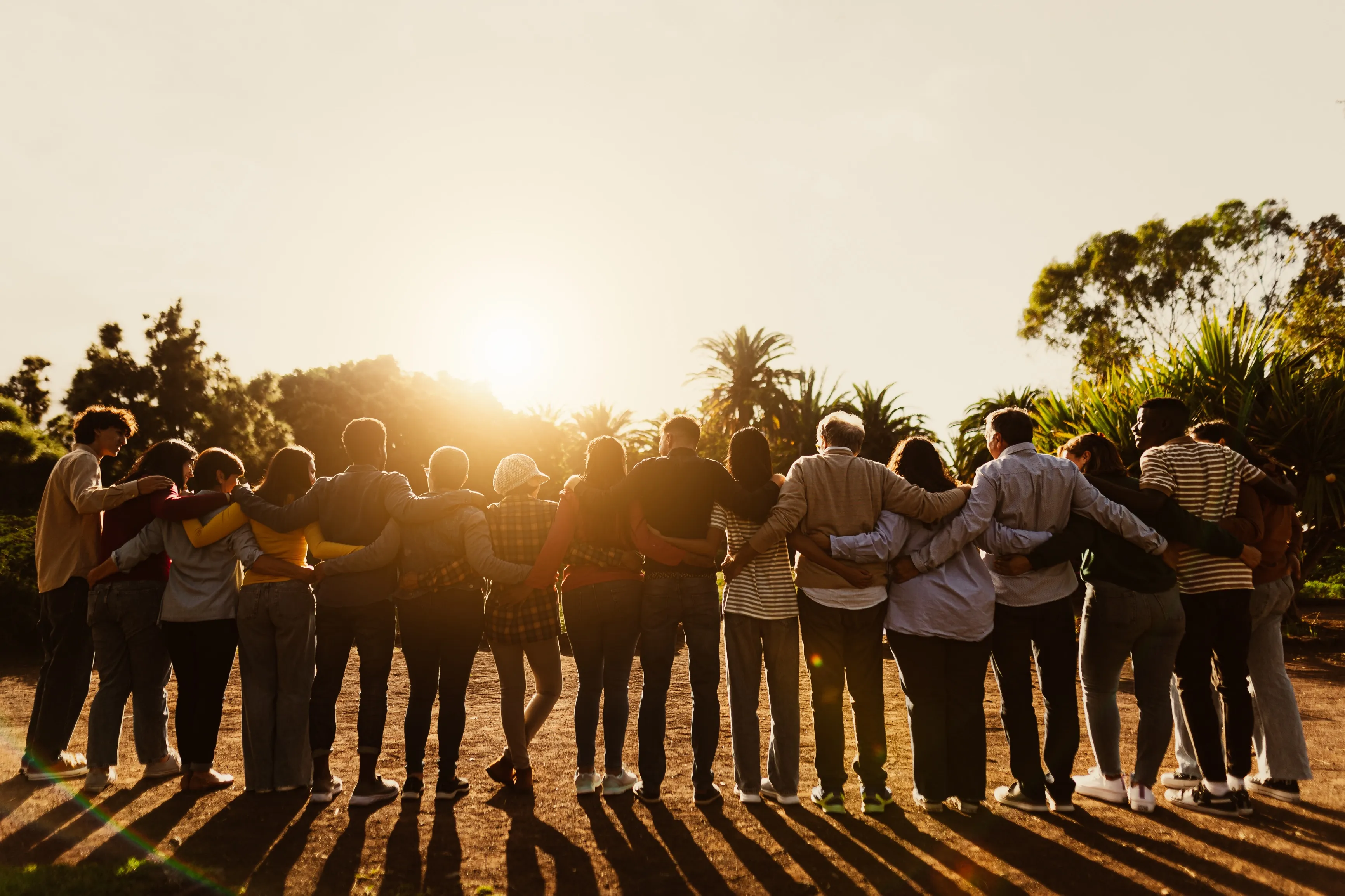 Community standing together at sunset
