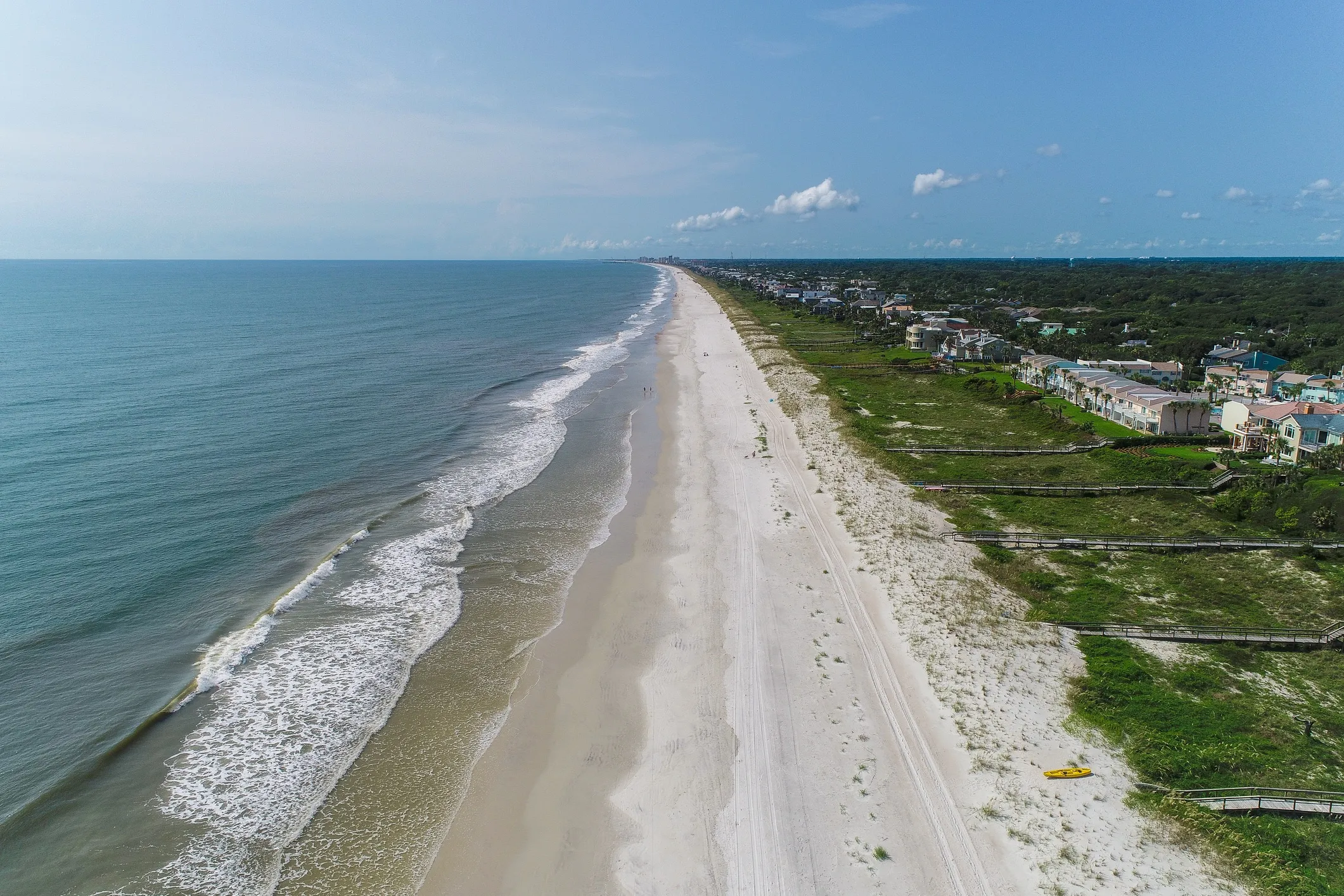 Aerial view of coastal homes and dunes along a Northeast Florida beach
