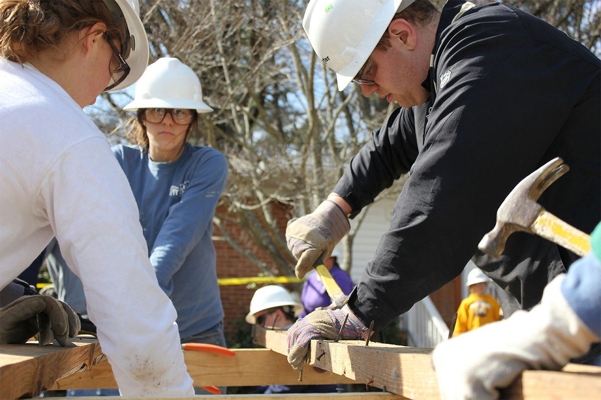Volunteers framing a structure together