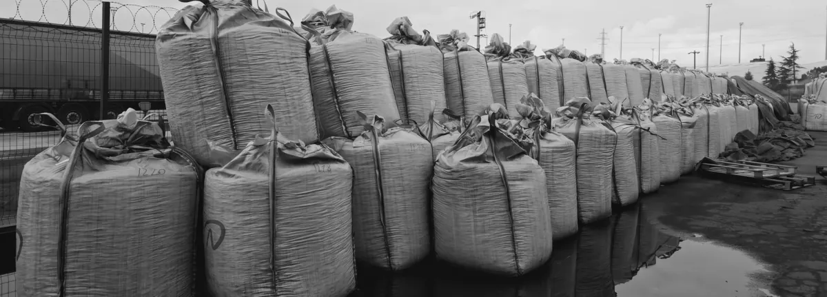 Rows of NEGIX-branded jumbo bags with numbered lots in an origin stockyard