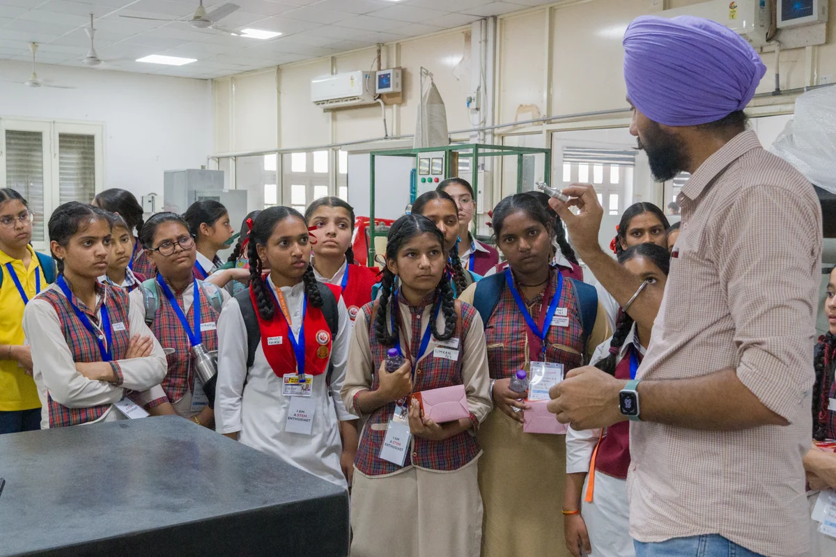 Students gathered around a teacher during a science demonstration.