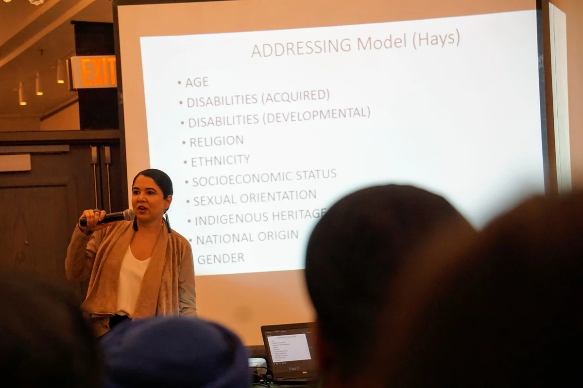 A speaker presenting to an audience at a Surat Initiative event.
