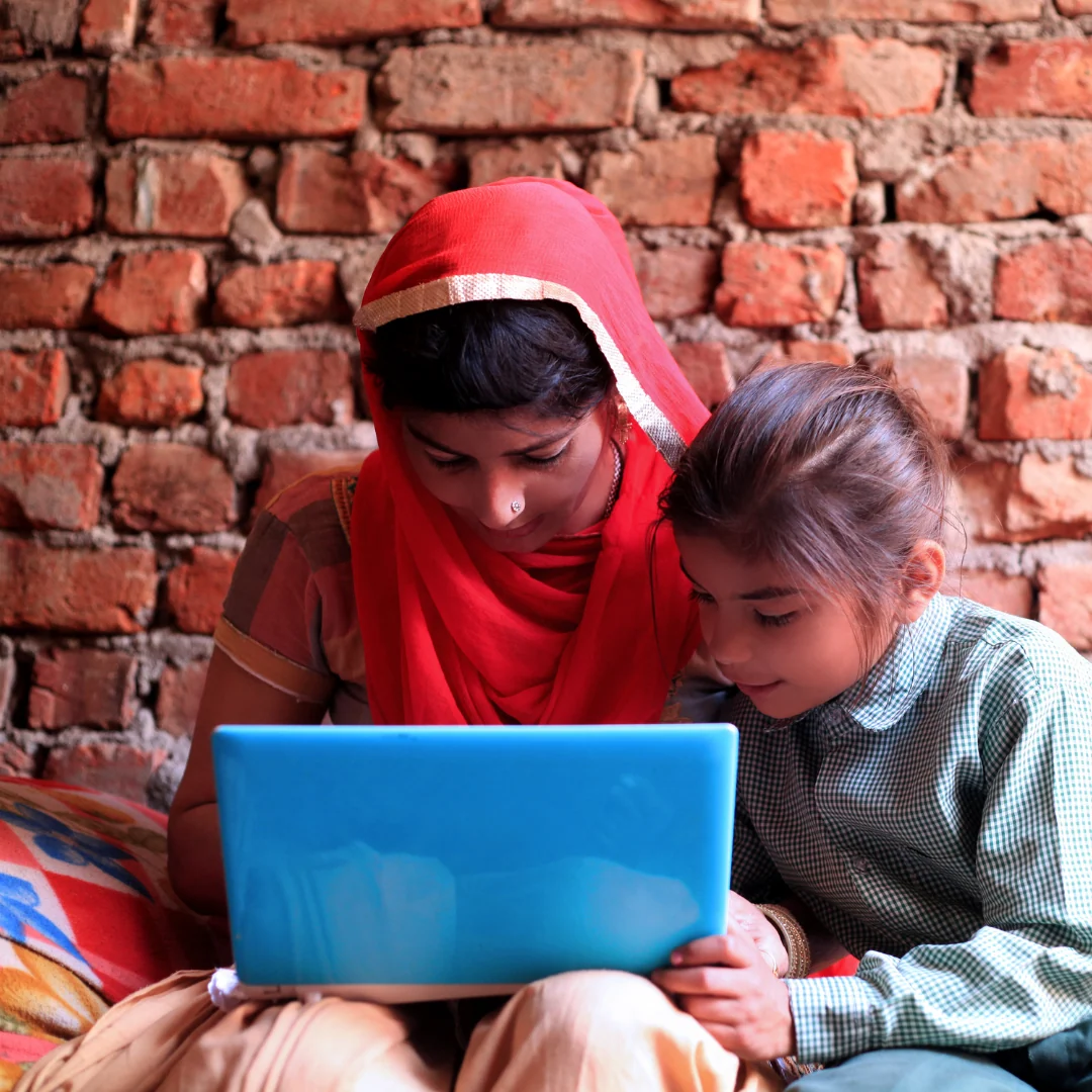 Two students learning together on a laptop.