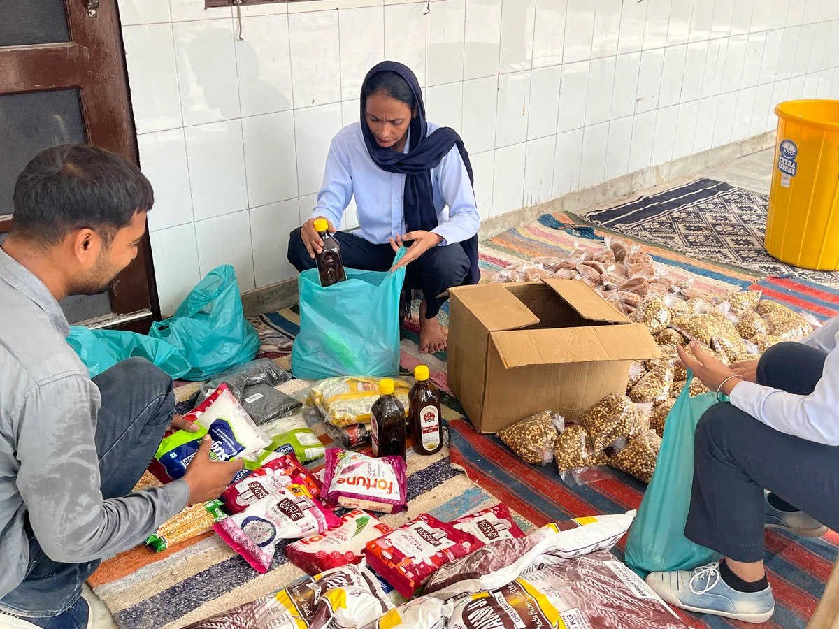 Volunteers packing food and essential supplies for distribution.