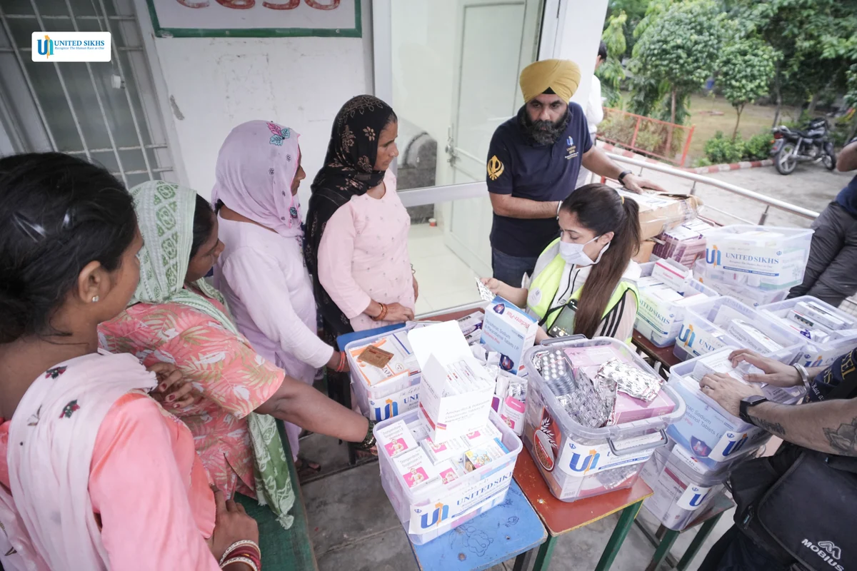 Volunteers providing medicines at a community medical outreach table.