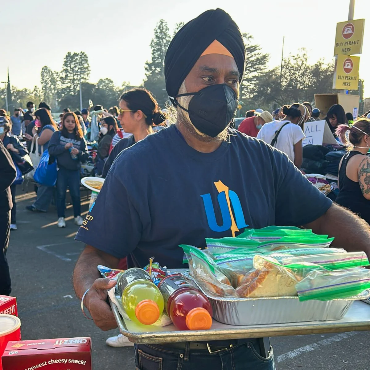 A volunteer carrying prepared meals for distribution.