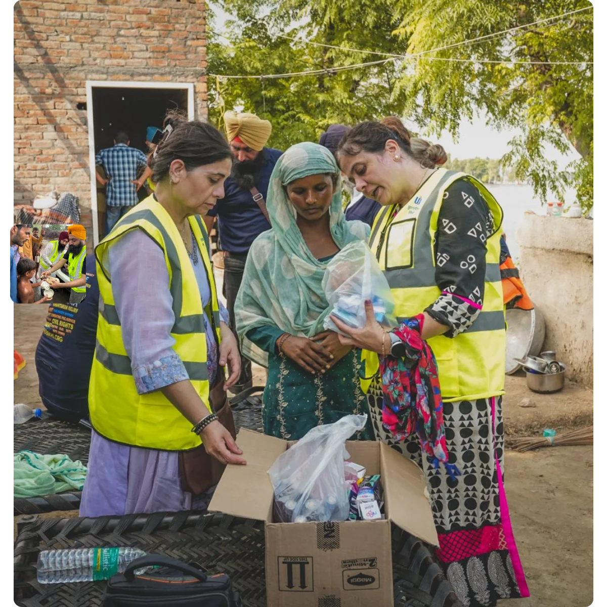 Relief volunteers handing essential supplies to a family.