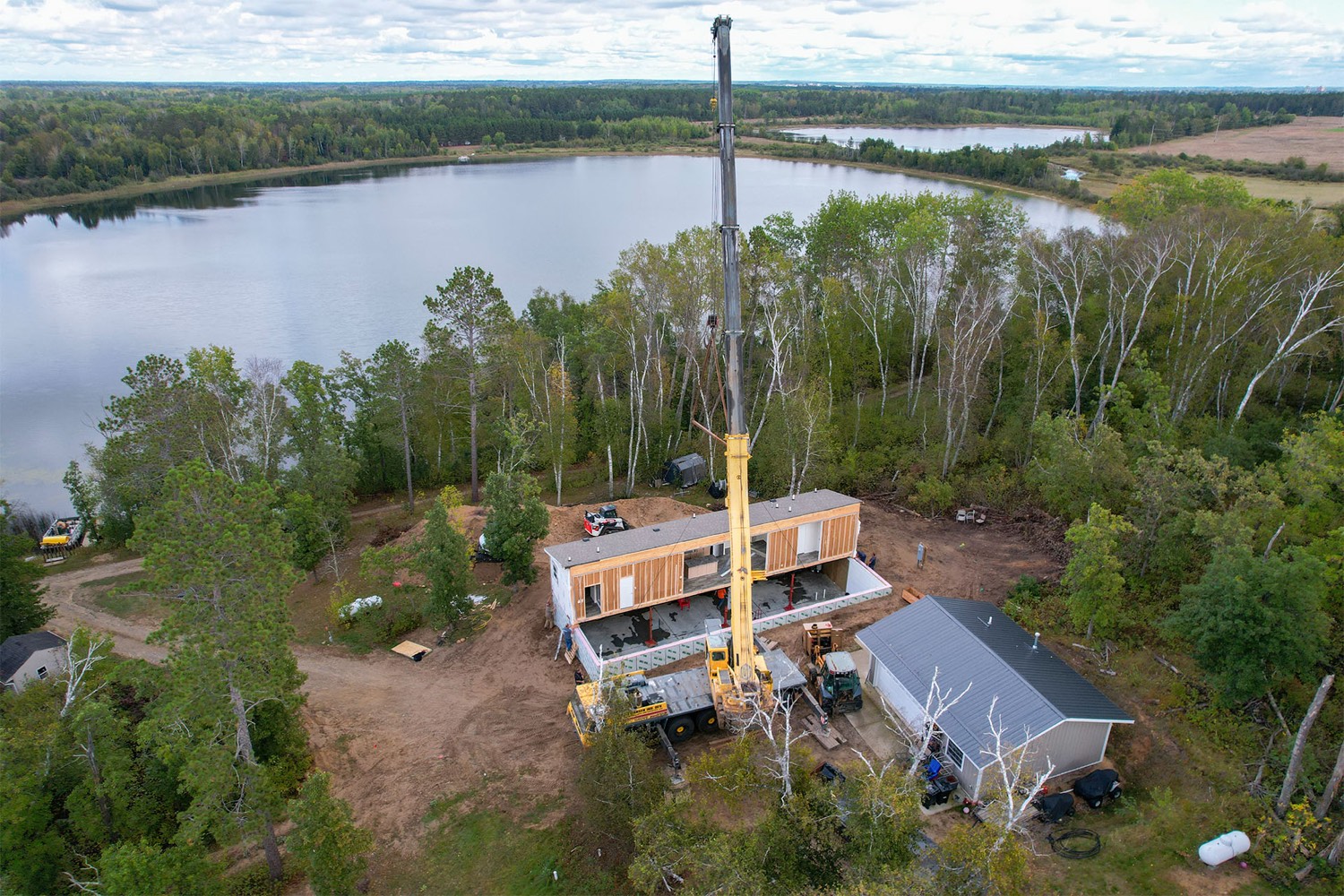 A Village Homes home being set in place by crane on a lakeside lot