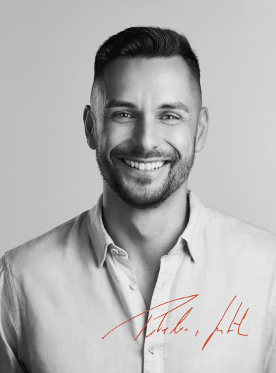 Black and white portrait of a Guenther with short dark hair and a trimmed beard wearing a light-colored button-up shirt.