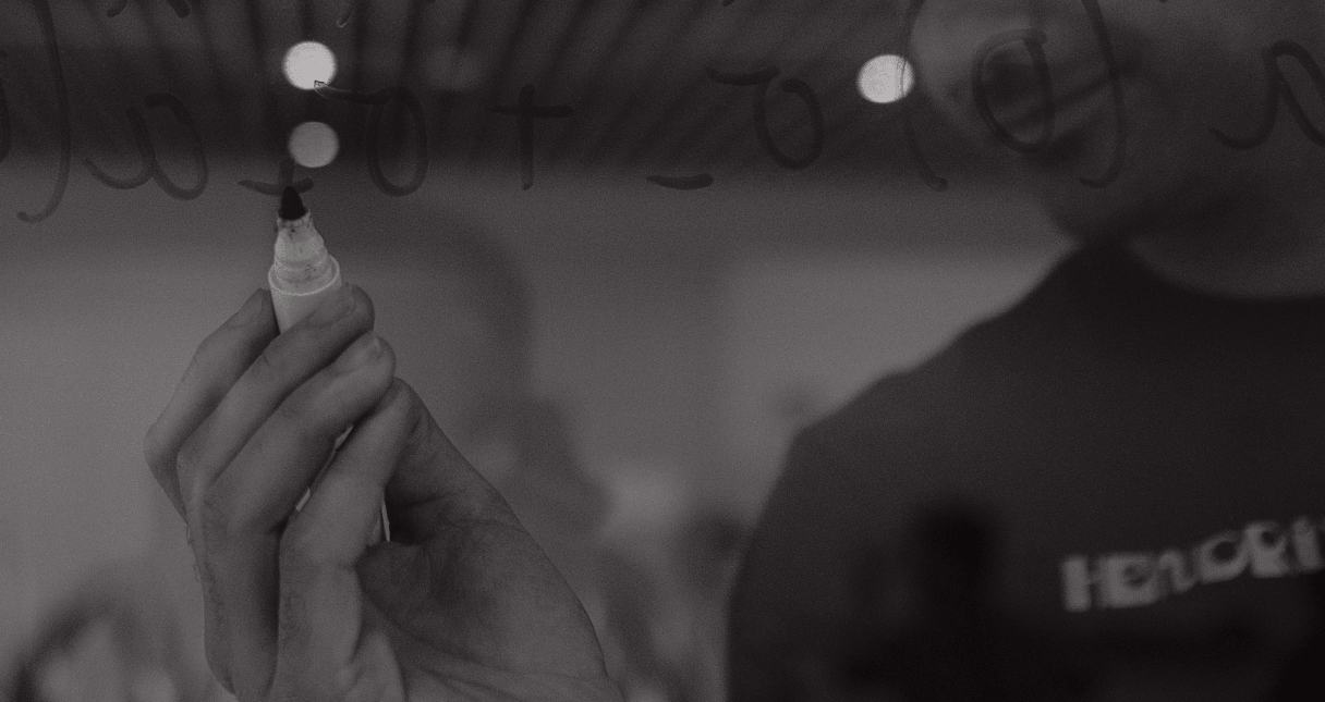 Close up of a man writing on glass