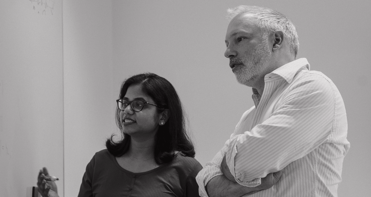 Image of a man and woman talking to a whiteboard