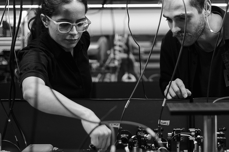 Image of a man and woman looking down at equipment
