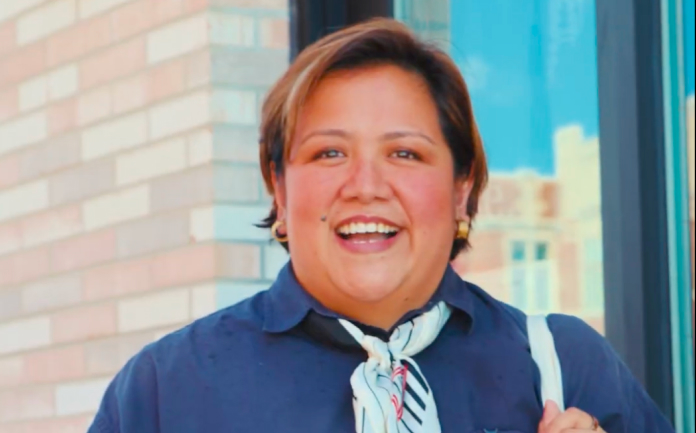 A photo of Frances wearing a blue and white striped ascot and blue shirt dress.