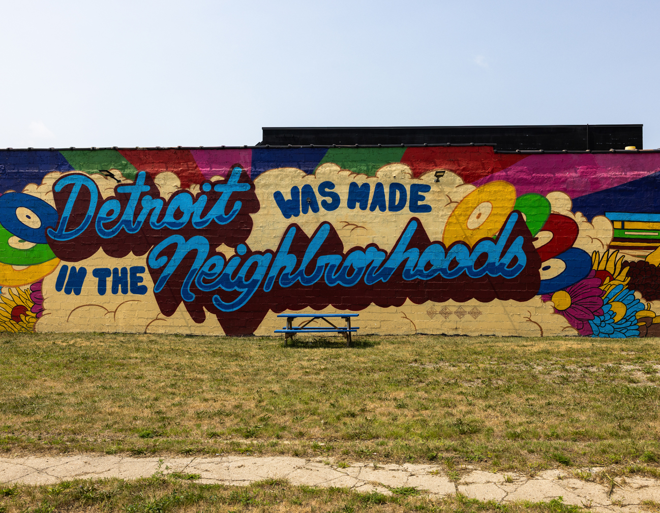 Brick wall mural with colorful background and stylized text that reads "Detroit was made in the Neighborhood."
