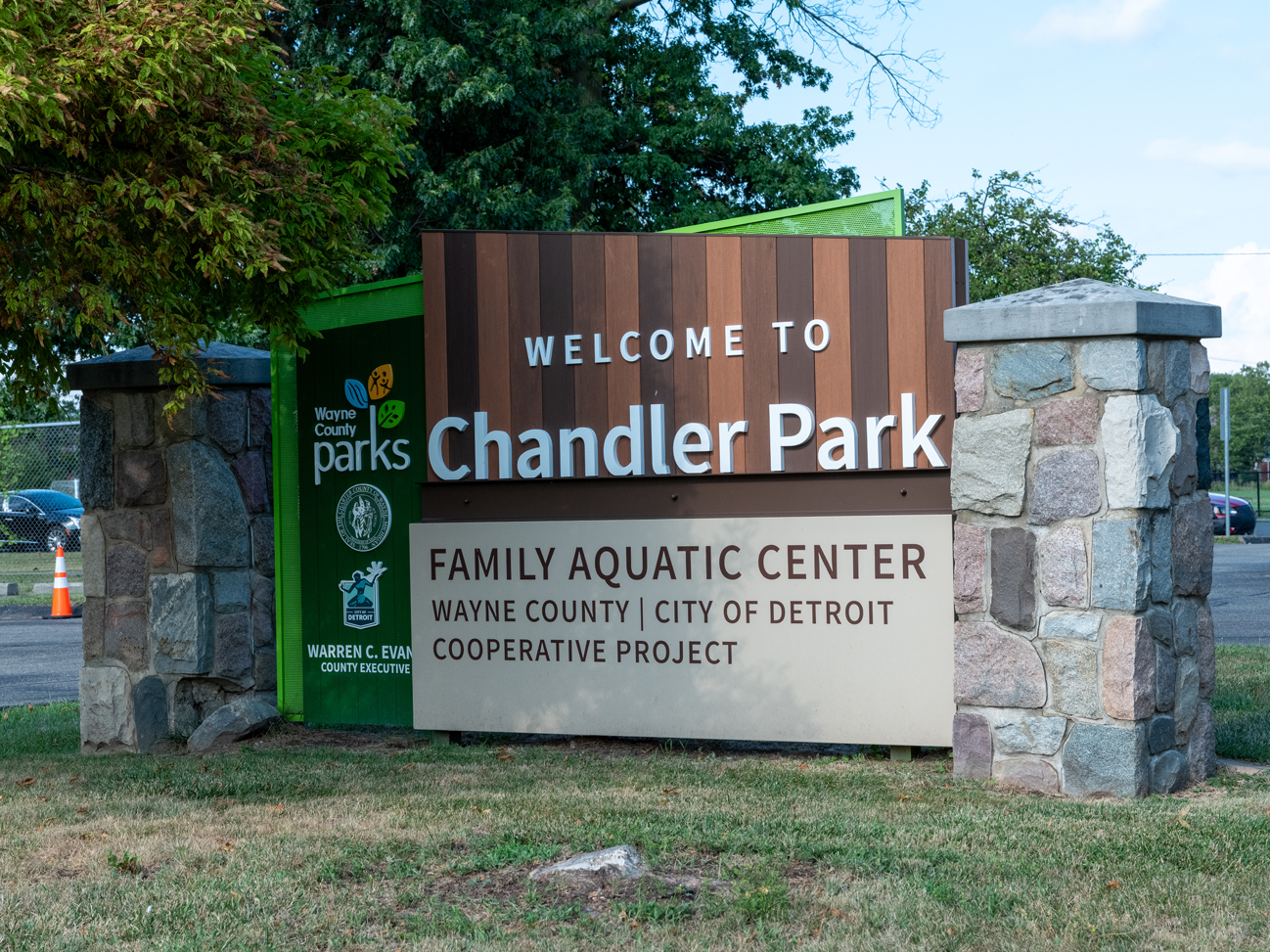A photo of a sign that says "Welcome to Chandler Park" and below, "Family Aquatic Center, Wayne County | City of Detroit Cooperative Project."