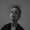 Black and white portrait of a person with short hair and glasses looking slightly upward.