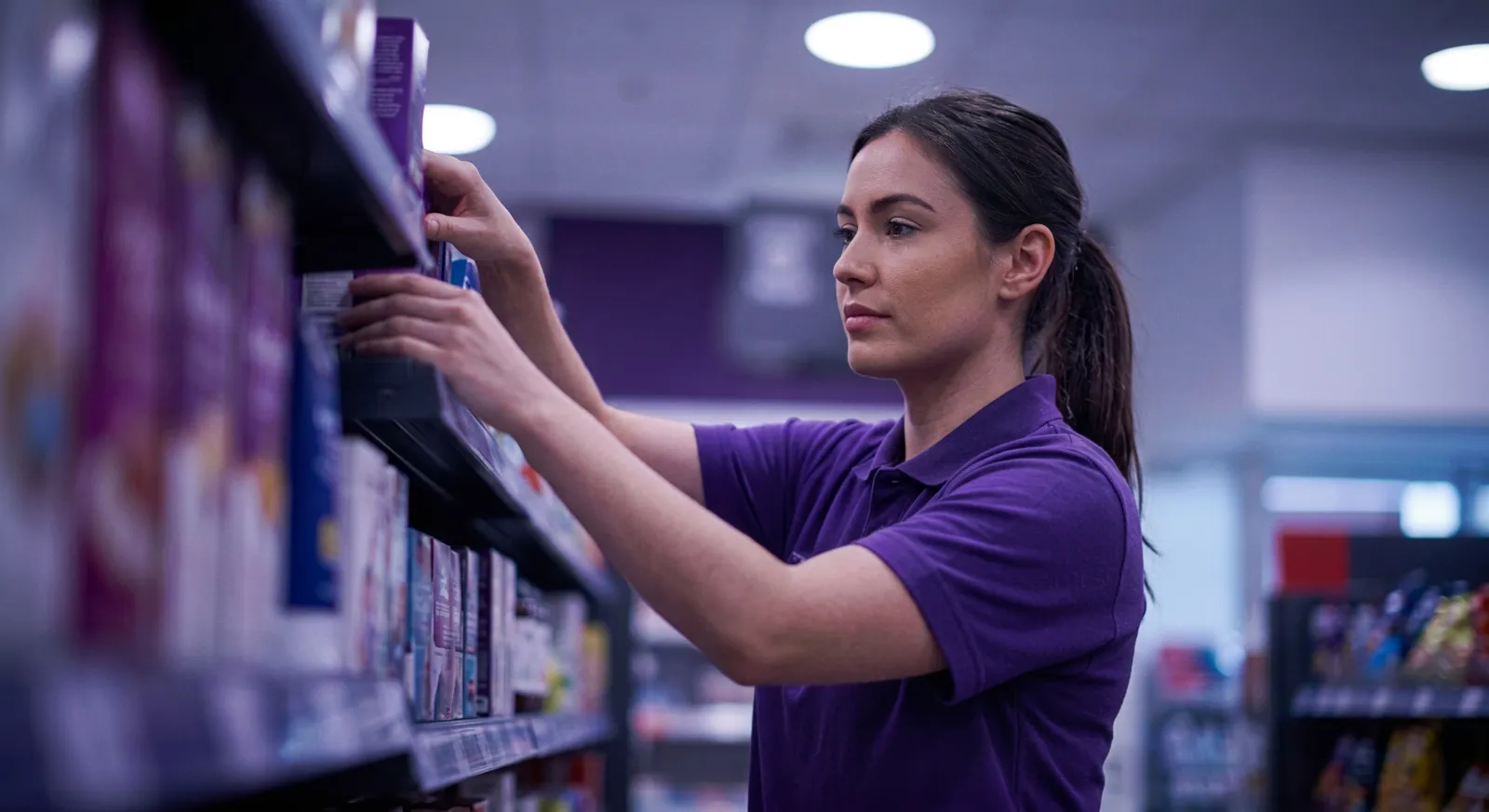 Store colleague restocking a shelf