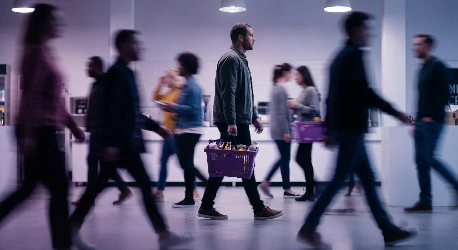 Shoppers walking through a store with baskets